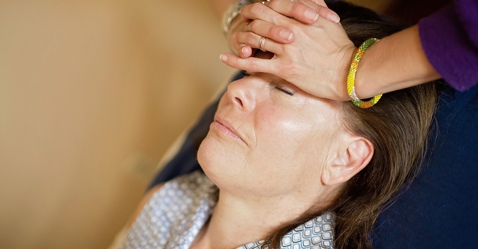 A woman receiving a calming head massage.