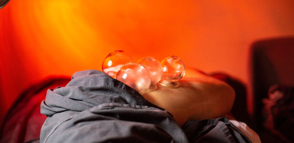 Person resting with water droplets on face against an orange background.