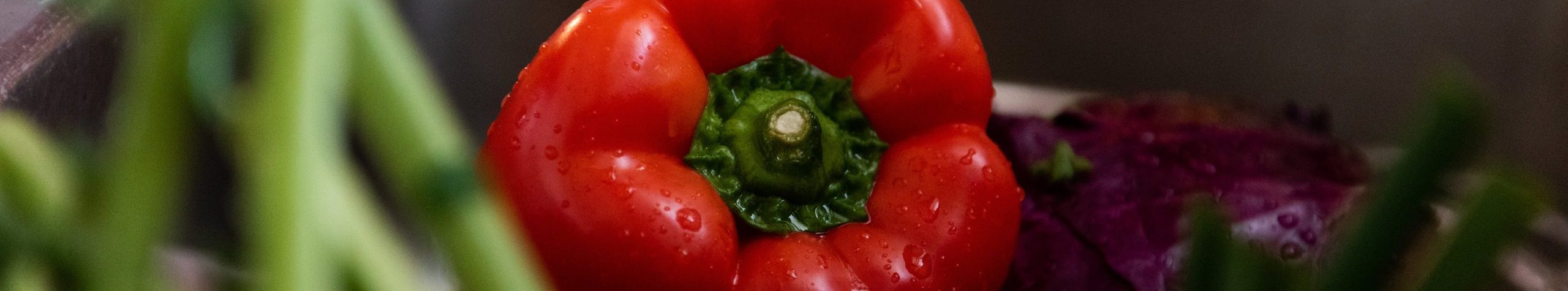 Close-up of a fresh red bell pepper with green stem.