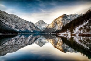 Snowy mountains reflecting on a tranquil lake.